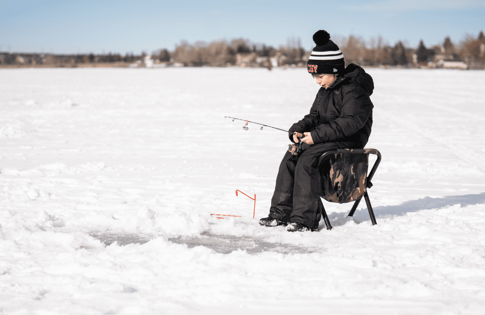 A child is seen ice fishing on Chestermere Lake
