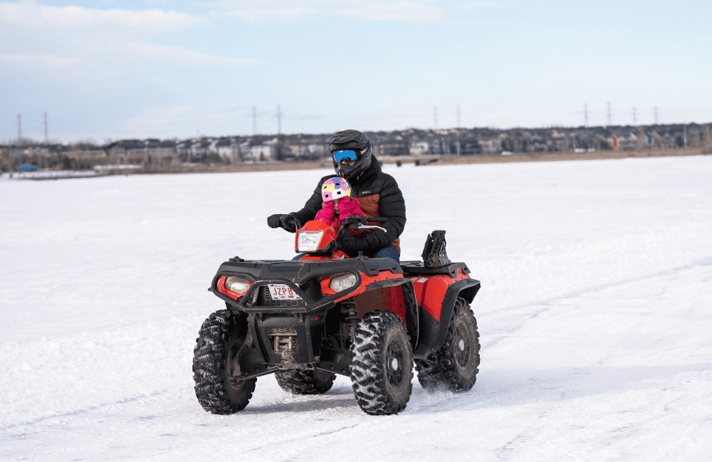 A quad (or OHV) is seen driving on the ice