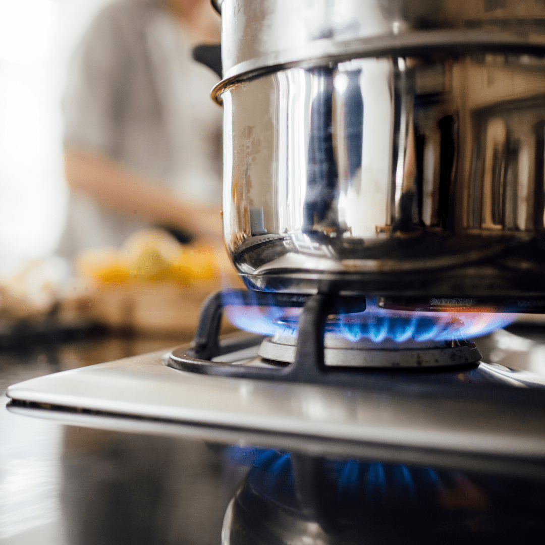 A pot being heated on a stove with a gas burner