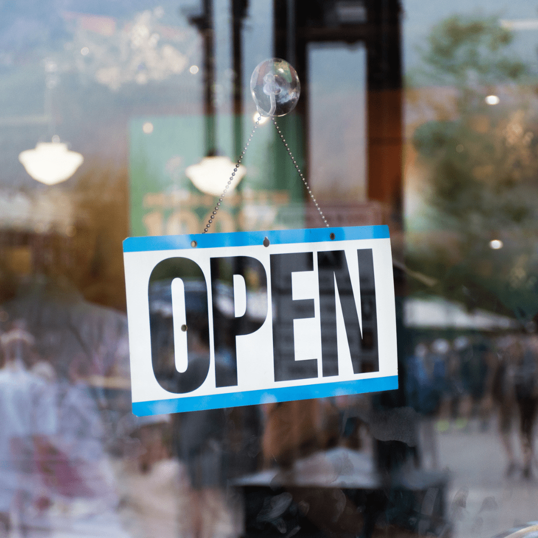 An open sign hangs in the front window of a business