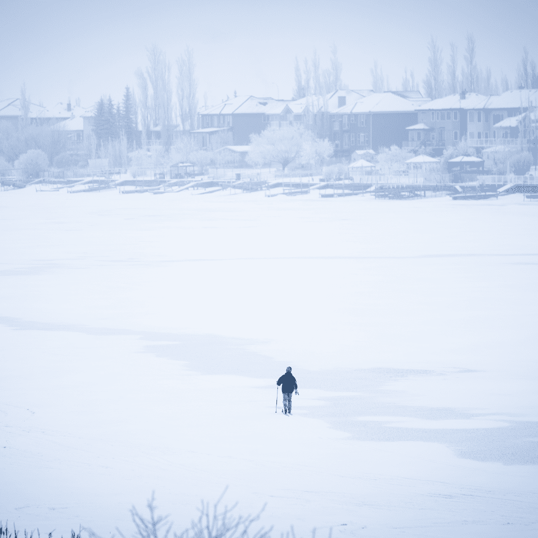 A man walks on a snowy Chestermere Lake