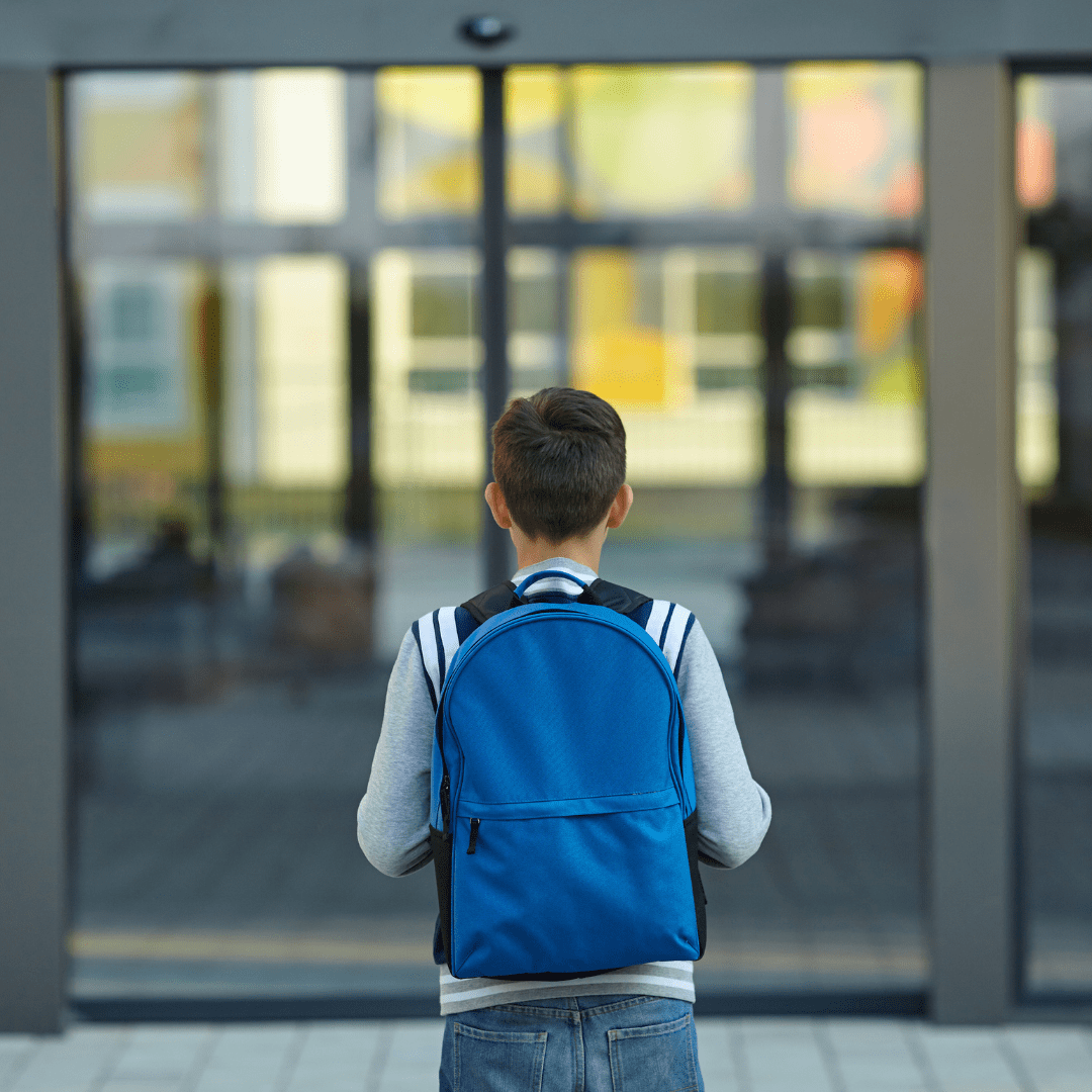 A child is seen with a blue backpack
